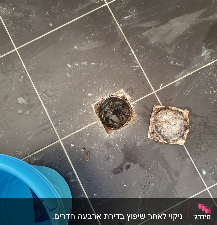 רצפה מלוכלכת עם דלי כחול ופתח ניקוז